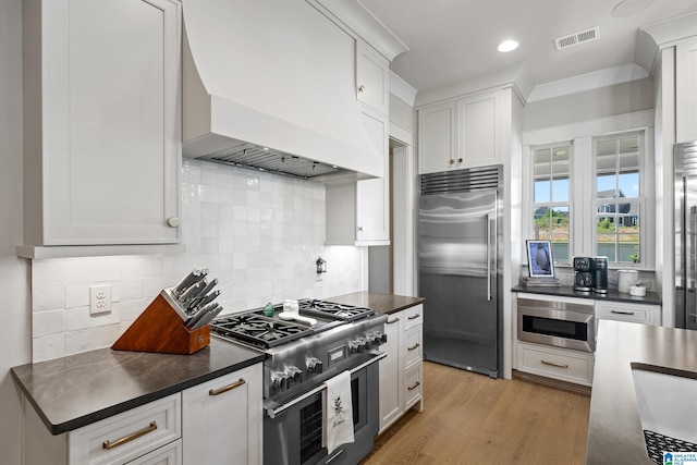 544 Preserve Way, Hoover, AL 35226 - kitchen with high quality appliances, premium range hood, dark countertops, white cabinets, and recessed lighting
