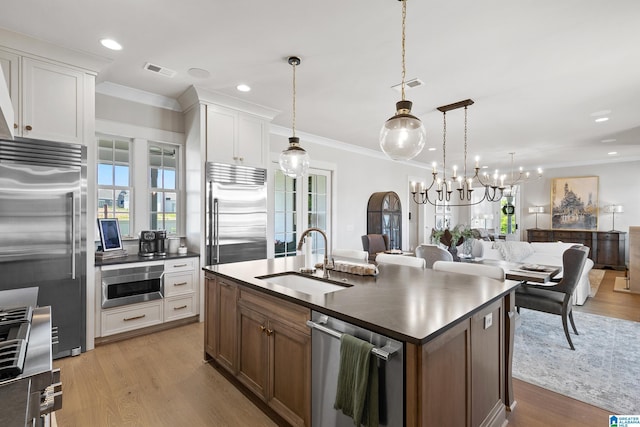 544 Preserve Way, Hoover, AL 35226 - kitchen featuring stainless steel appliances, dark countertops, light wood finished floors, a chandelier, and crown molding