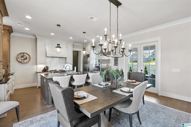 544 Preserve Way, Hoover, AL 35226 - dining space with ornamental molding, french doors, a chandelier, wood finished floors, and recessed lighting
