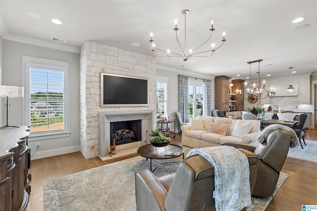 544 Preserve Way, Hoover, AL 35226 - living room with a chandelier, crown molding, healthy amount of natural light, a stone fireplace, and wood finished floors