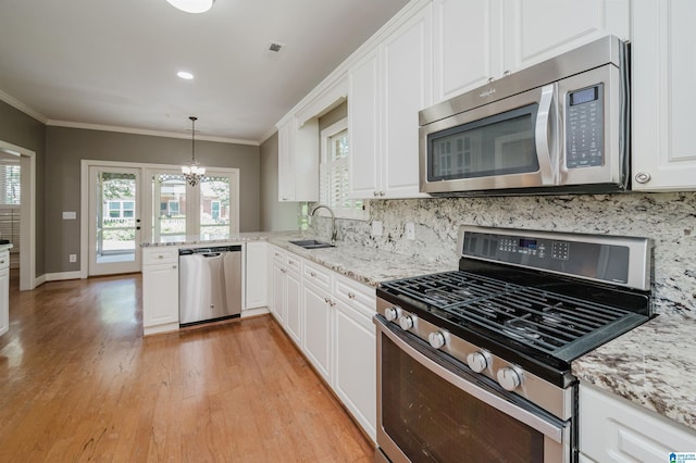 932 Cove Cir, Hoover, AL 35244 - kitchen featuring stainless steel appliances, backsplash, light wood-style flooring, ornamental molding, and white cabinetry