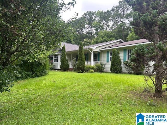 327 Canyon Ridge Rd, Sylacauga, AL 35151 - ranch-style house featuring a porch and a front lawn