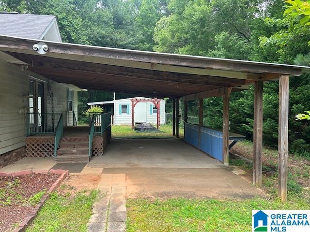 327 Canyon Ridge Rd, Sylacauga, AL 35151 - view of parking with an attached carport and a view of trees