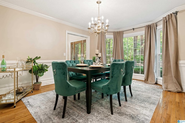 4737 Cloud Ln, Birmingham, AL 35243 - dining space featuring crown molding, a chandelier, light wood-style floors, and a wainscoted wall