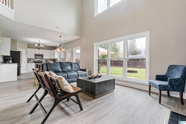 483 Old Cahaba Way, Helena, AL 35080 - living room featuring a chandelier, a high ceiling, plenty of natural light, and light wood-style flooring