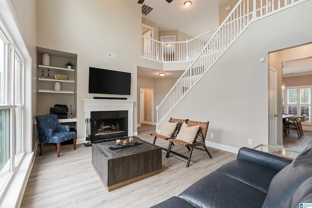 483 Old Cahaba Way, Helena, AL 35080 - living area with a towering ceiling, light wood-style flooring, a ceiling fan, a fireplace with flush hearth, and stairs