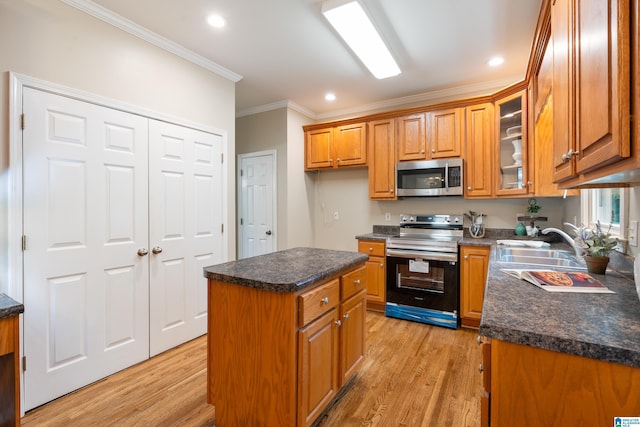1812 Cross Cir, Hoover, AL 35244 - kitchen featuring stainless steel appliances, crown molding, light wood-style flooring, brown cabinetry, and dark countertops