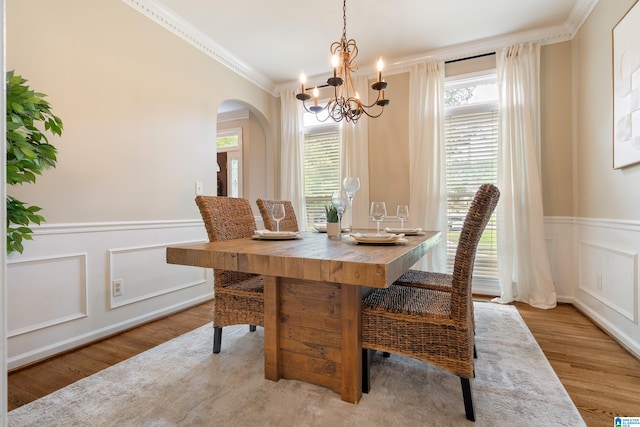 1812 Cross Cir, Hoover, AL 35244 - dining space with a chandelier, arched walkways, ornamental molding, wood finished floors, and a wainscoted wall