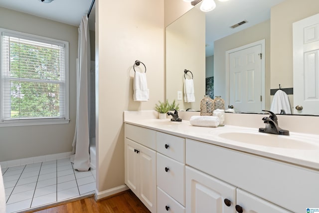 1812 Cross Cir, Hoover, AL 35244 - full bath with double vanity, plenty of natural light, wood finished floors, and shower / bathtub combination with curtain