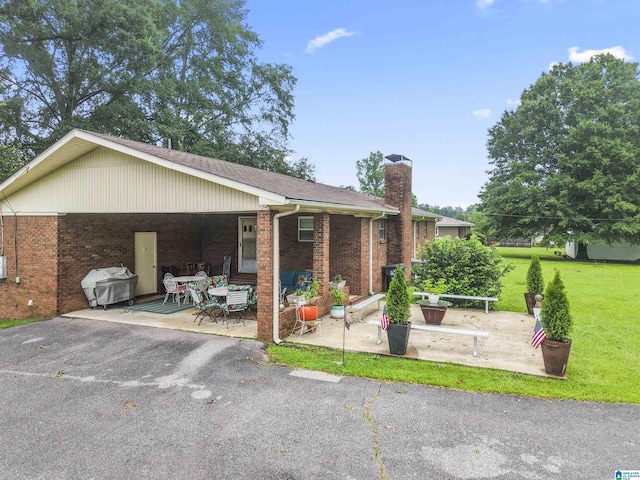 8892 Moody Pkwy, Odenville, AL 35120 - ranch-style house featuring brick siding, a front lawn, a chimney, and a patio area