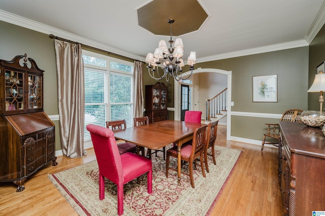 4208 Waterford Ln, Trussville, AL 35173 - dining space featuring a chandelier, light wood-style floors, ornamental molding, and arched walkways