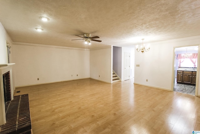 1534 Cambridge Pl, Anniston, AL 36207 - unfurnished living room featuring a chandelier, ceiling fan, stairway, a textured ceiling, and light wood-style flooring