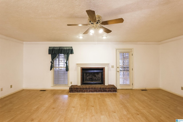 1534 Cambridge Pl, Anniston, AL 36207 - unfurnished living room with wood finished floors, a textured ceiling, a fireplace, ceiling fan, and crown molding