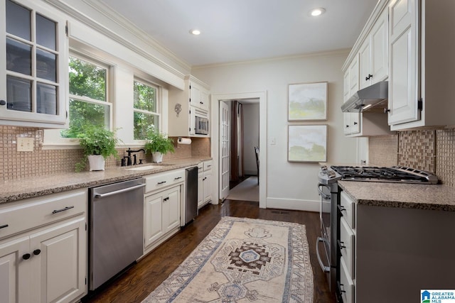 117 Elm St, Mountain Brook, AL 35213 - kitchen featuring stainless steel appliances, decorative backsplash, crown molding, under cabinet range hood, and white cabinetry