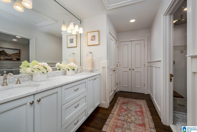 117 Elm St, Mountain Brook, AL 35213 - bathroom with double vanity, a tile shower, wood finished floors, and recessed lighting