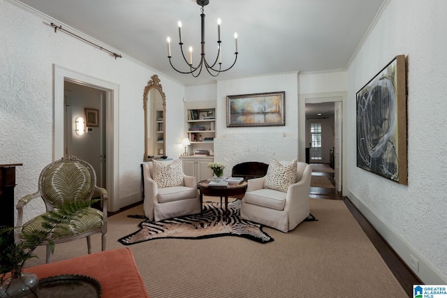 117 Elm St, Mountain Brook, AL 35213 - carpeted living area featuring a fireplace, crown molding, a chandelier, a textured wall, and built in features