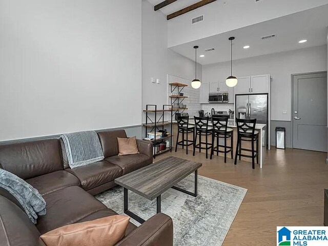2212 Morris Ave Unit 323, Birmingham, AL 35203 - living area with a towering ceiling, beamed ceiling, wood finished floors, and recessed lighting
