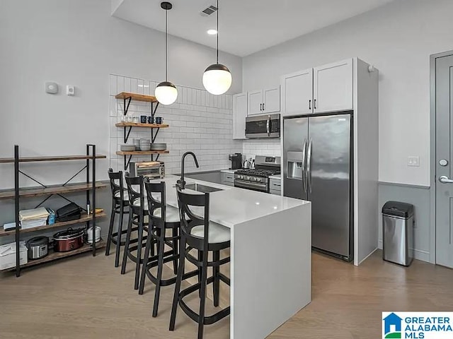 2212 Morris Ave Unit 323, Birmingham, AL 35203 - kitchen with stainless steel appliances, a peninsula, tasteful backsplash, open shelves, and a kitchen bar