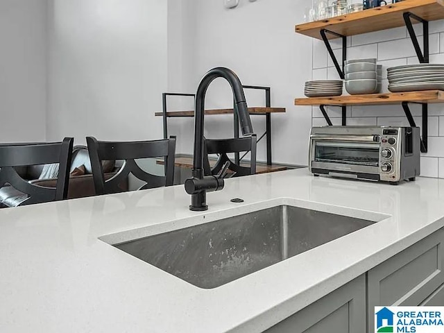 2212 Morris Ave Unit 323, Birmingham, AL 35203 - kitchen view of open shelves, gray cabinetry, decorative backsplash, and light countertops