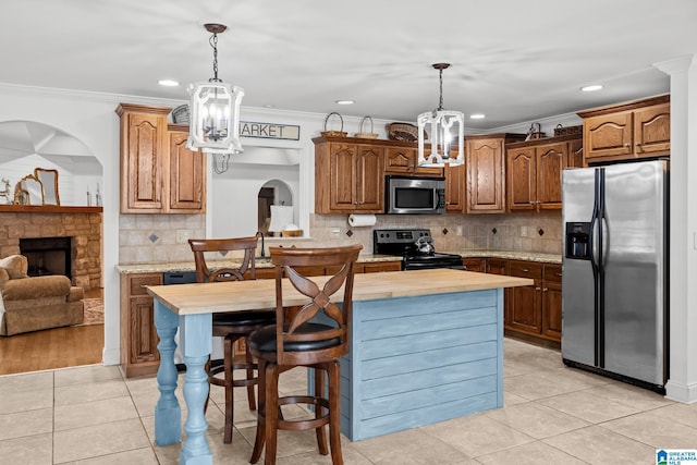 2043 Maplewood Ln, Clanton, AL 35045 - kitchen with stainless steel appliances, a chandelier, light tile patterned floors, tasteful backsplash, and crown molding