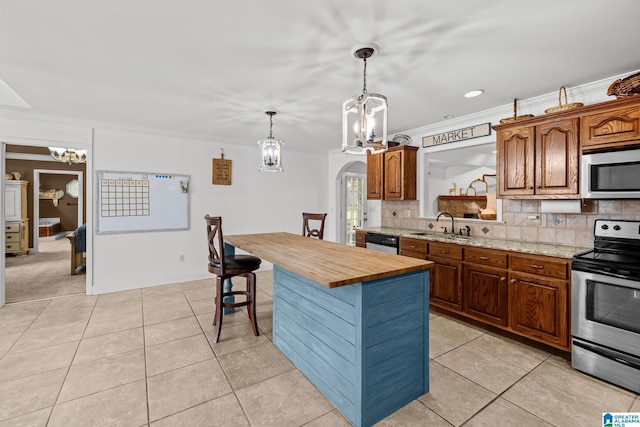 2043 Maplewood Ln, Clanton, AL 35045 - kitchen featuring appliances with stainless steel finishes, a chandelier, a breakfast bar area, tasteful backsplash, and crown molding
