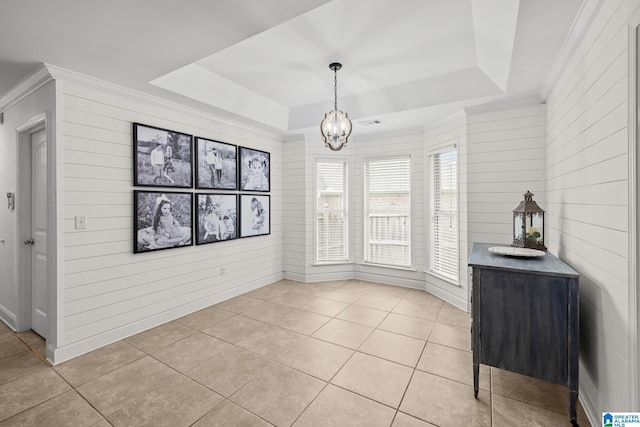 2043 Maplewood Ln, Clanton, AL 35045 - unfurnished dining area with a raised ceiling, crown molding, light tile patterned floors, a chandelier, and wooden walls