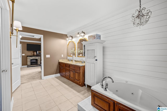 2043 Maplewood Ln, Clanton, AL 35045 - bathroom with double vanity, a stone fireplace, a jetted tub, a chandelier, and crown molding