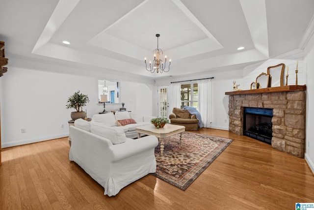 2043 Maplewood Ln, Clanton, AL 35045 - living room featuring a tray ceiling, a chandelier, a fireplace, recessed lighting, and wood finished floors