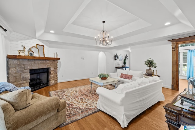 2043 Maplewood Ln, Clanton, AL 35045 - living area with a tray ceiling, a chandelier, arched walkways, a stone fireplace, and recessed lighting