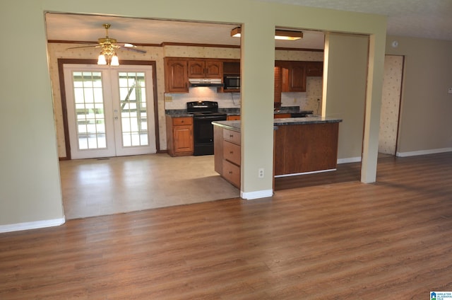 6301 Cedar Ct, Anniston, AL 36206 - kitchen with black appliances, under cabinet range hood, dark countertops, light wood-style flooring, and open floor plan