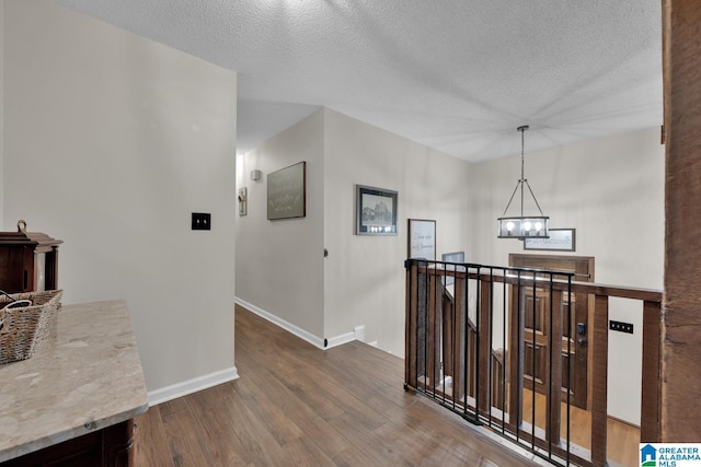 1025 Old Section Rd, Hoover, AL 35244 - hall featuring an upstairs landing, wood finished floors, a chandelier, and a textured ceiling