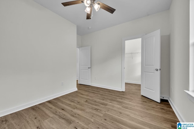 7945 Forest Loop, Pinson, AL 35126 - unfurnished bedroom with wood finished floors, a spacious closet, a closet, and a ceiling fan