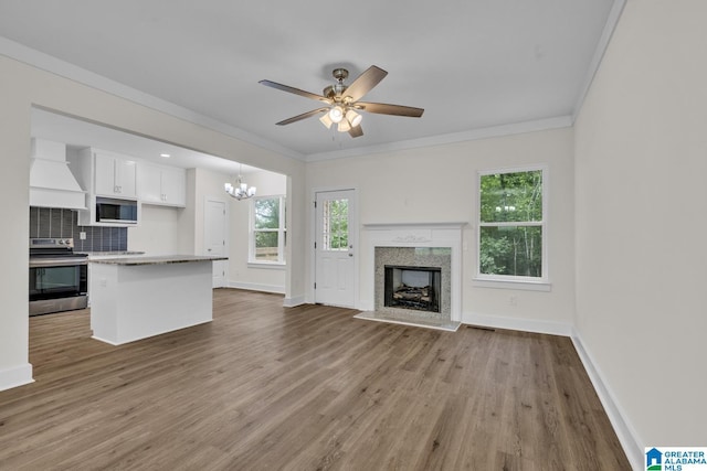 7945 Forest Loop, Pinson, AL 35126 - unfurnished living room featuring ornamental molding, a chandelier, wood finished floors, and plenty of natural light