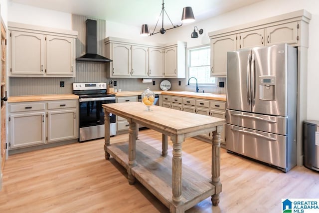 1004 Broken Bow Trl, Alabaster, AL 35007 - kitchen with appliances with stainless steel finishes, wall chimney range hood, light wood-type flooring, and light countertops