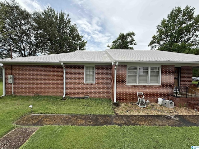 49 Cave Rd, Anniston, AL 36206 - view of property exterior with a lawn, brick siding, and a metal roof
