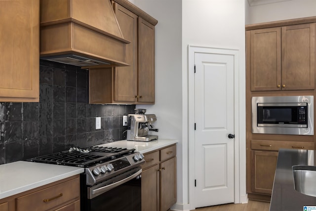 1313 Severn Way, Hoover, AL 35244 - kitchen featuring appliances with stainless steel finishes, decorative backsplash, custom exhaust hood, light countertops, and brown cabinets