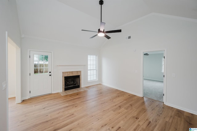 4022 Cambridge Dr, Moody, AL 35004 - unfurnished living room featuring ceiling fan, light wood-style floors, a tiled fireplace, ornamental molding, and high vaulted ceiling