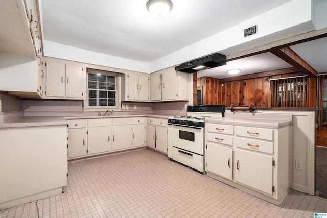 805 Vanderbilt St, Birmingham, AL 35206 - kitchen featuring white gas stove, range hood, light countertops, and white cabinets