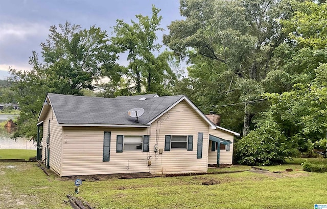 11201 Woodland Dr, Mccalla, AL 35111 - view of front of house with a front yard, a shingled roof, and view of scattered trees