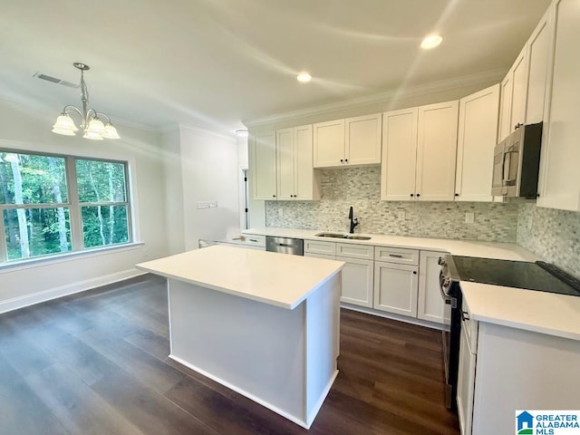 1029 Creel Dr, Moody, AL 35004 - kitchen featuring appliances with stainless steel finishes, crown molding, dark wood-type flooring, backsplash, and light countertops
