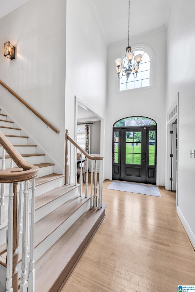 5012 Lake Crest Cir, Hoover, AL 35226 - entrance foyer with crown molding, a chandelier, light wood-style flooring, stairway, and a high ceiling