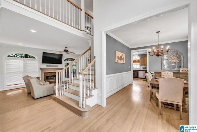 5012 Lake Crest Cir, Hoover, AL 35226 - dining space featuring a fireplace, healthy amount of natural light, a ceiling fan, a chandelier, and crown molding