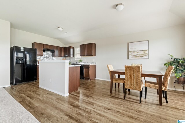 240 Hillcrest Dr, Montevallo, AL 35115 - kitchen with black refrigerator with ice dispenser, vaulted ceiling, light countertops, light wood-style floors, and dark brown cabinets