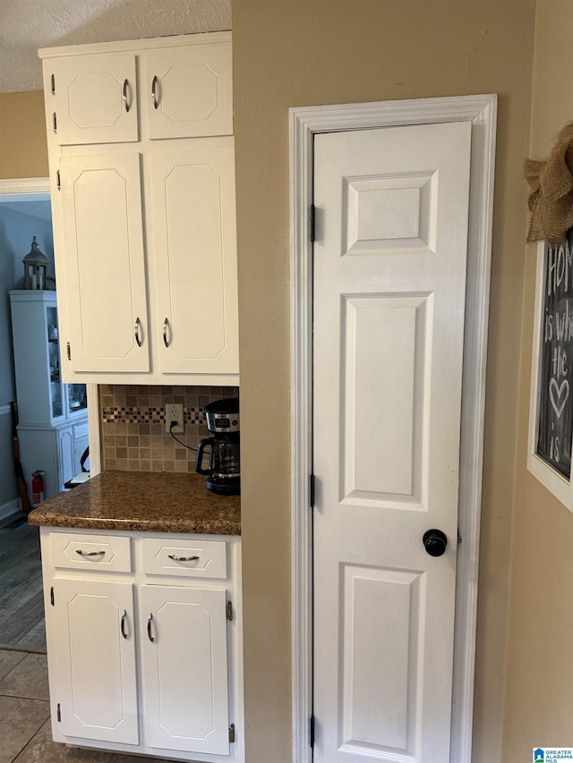 1500 Rockview Cir, Weaver, AL 36277 - kitchen with dark countertops, white cabinetry, and backsplash
