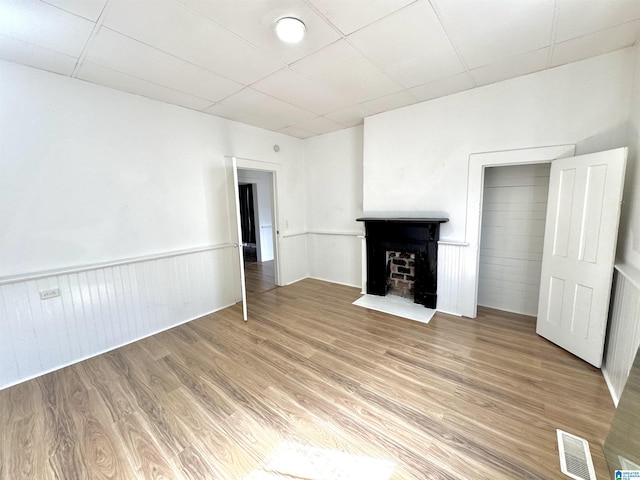 7604 3rd Ave S, Birmingham, AL 35206 - unfurnished living room featuring light wood-style floors and a wainscoted wall