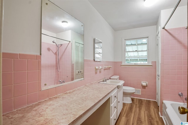 1257 Hueytown Rd, Hueytown, AL 35023 - full bath featuring tile walls, wood finished floors, vanity, wainscoting, and shower / tub combination