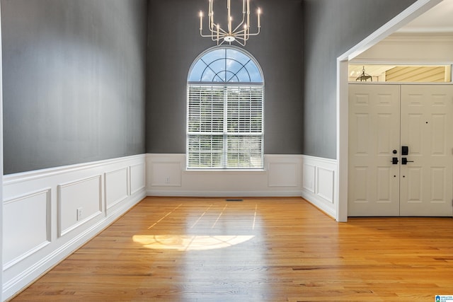 148 Grande View Ln, Alabaster, AL 35114 - entrance foyer featuring a chandelier, light wood-style flooring, a decorative wall, and a wainscoted wall