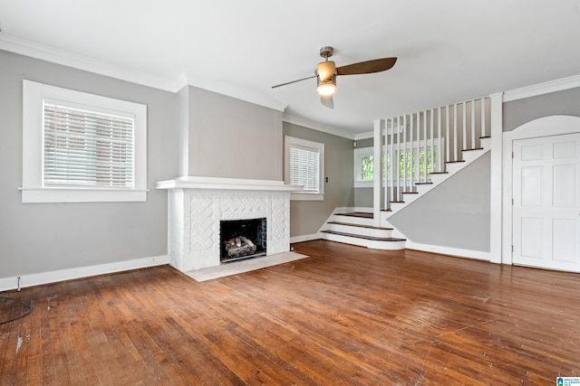 1701 S 16th Ave, Birmingham, AL 35205 - unfurnished living room with crown molding, a ceiling fan, a tiled fireplace, stairs, and wood-type flooring