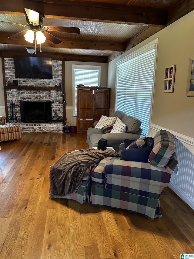 76 Goggins Dr, Montevallo, AL 35115 - living area featuring wood-type flooring, wainscoting, a ceiling fan, a fireplace, and a wooden ceiling with exposed beams