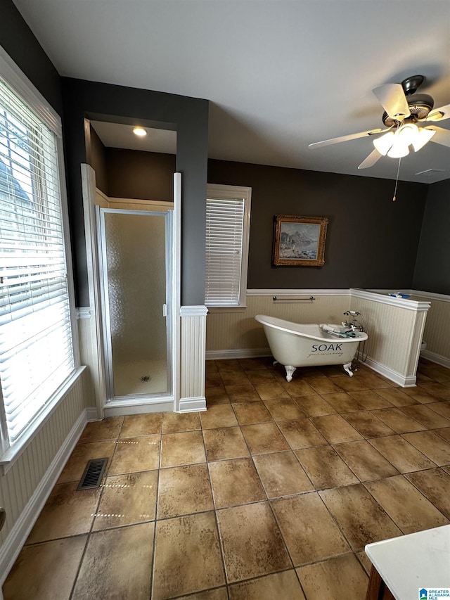 76 Goggins Dr, Montevallo, AL 35115 - full bathroom with a shower stall, a freestanding tub, wainscoting, ceiling fan, and tile patterned flooring